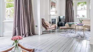 Een ruime woonkamer met een open haard, een televisie en een gezellige zithoek.