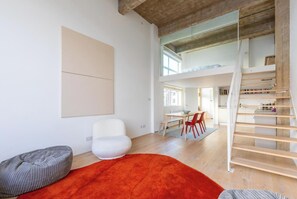 A modern interior with a staircase, a dining area, and a large window. - Chic 1BD Warehouse Conversion, Hackney (Greater London)