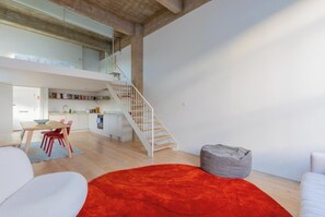 A modern interior with a staircase, a dining area, and a living space. - Chic 1BD Warehouse Conversion, Hackney (Greater London)