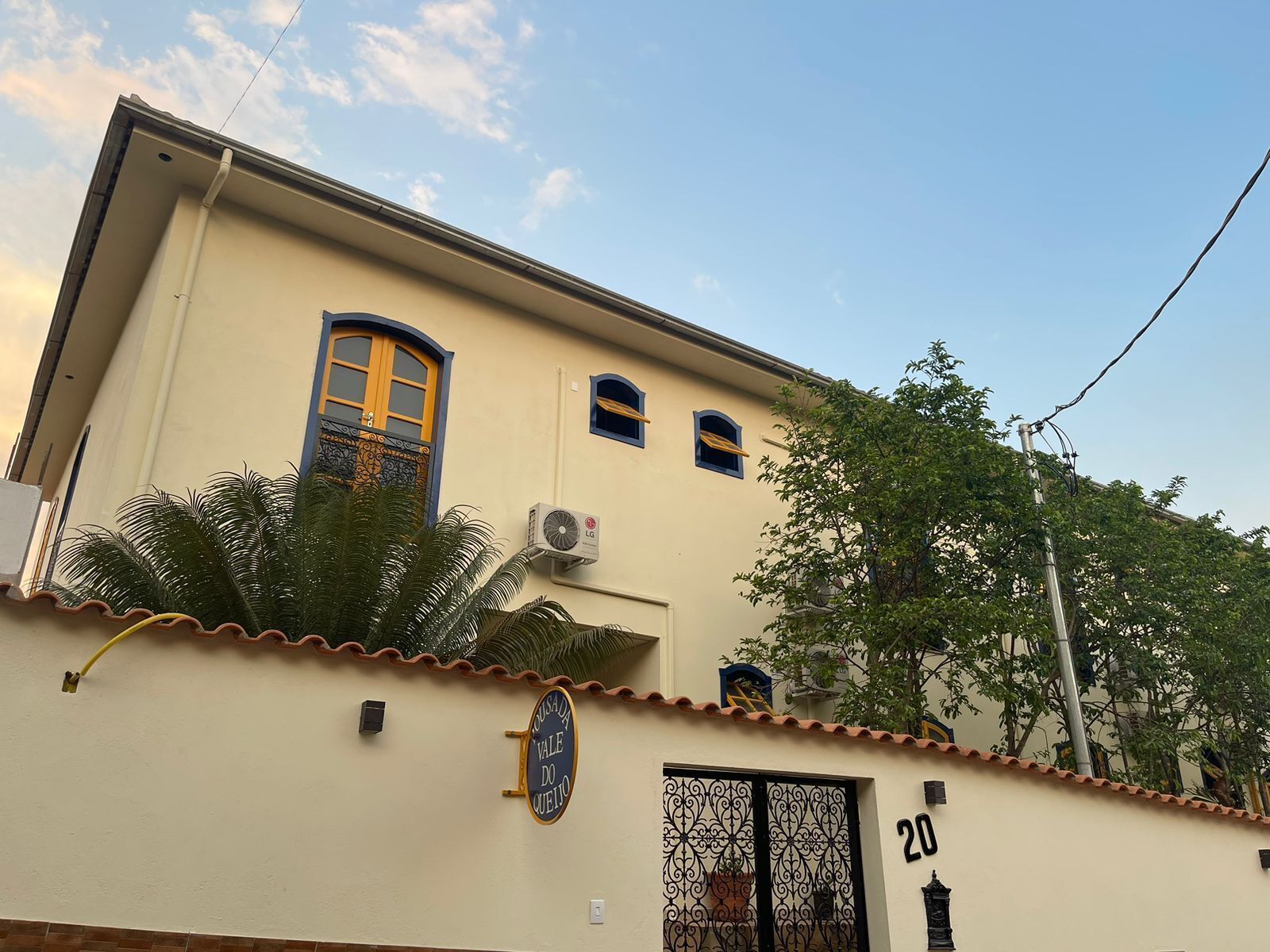 A building with a beige facade, a tiled roof, and a number '20' on the wall.