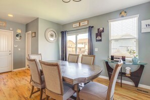 A dining area with a round table, six chairs, and a glass-top coffee table.