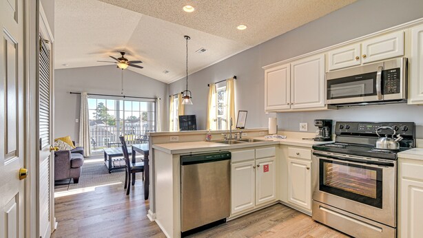 A modern kitchen with white cabinets, stainless steel appliances, and a dishwasher. - Pool + Hot Tub: Lake-view Condo in Surfside Beach! (Surfside Beach)