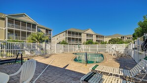 A pool area with lounge chairs and a sign indicating shallow water no diving. - Pool + Hot Tub: Lake-view Condo in Surfside Beach! (Surfside Beach)