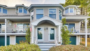 Ein zweigeschossiges Haus mit Veranda, Garage und einer kleinen Terrasse.