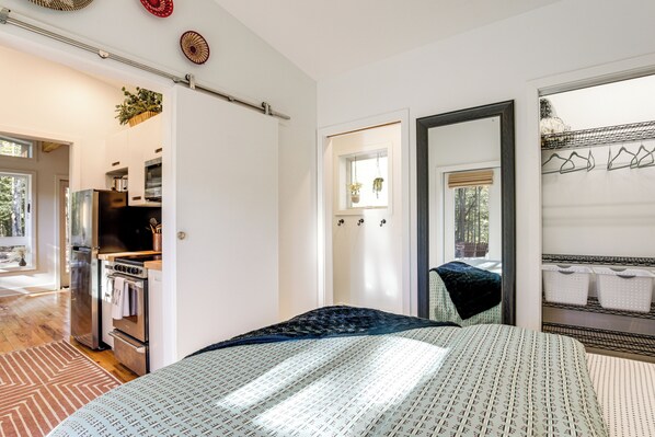 Une chambre à coucher avec un grand lit, une commode et une fenêtre donnant sur l’extérieur.