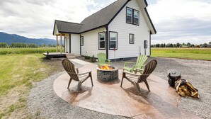 Une maison avec un foyer extérieur et des sièges pour profiter de l’extérieur.