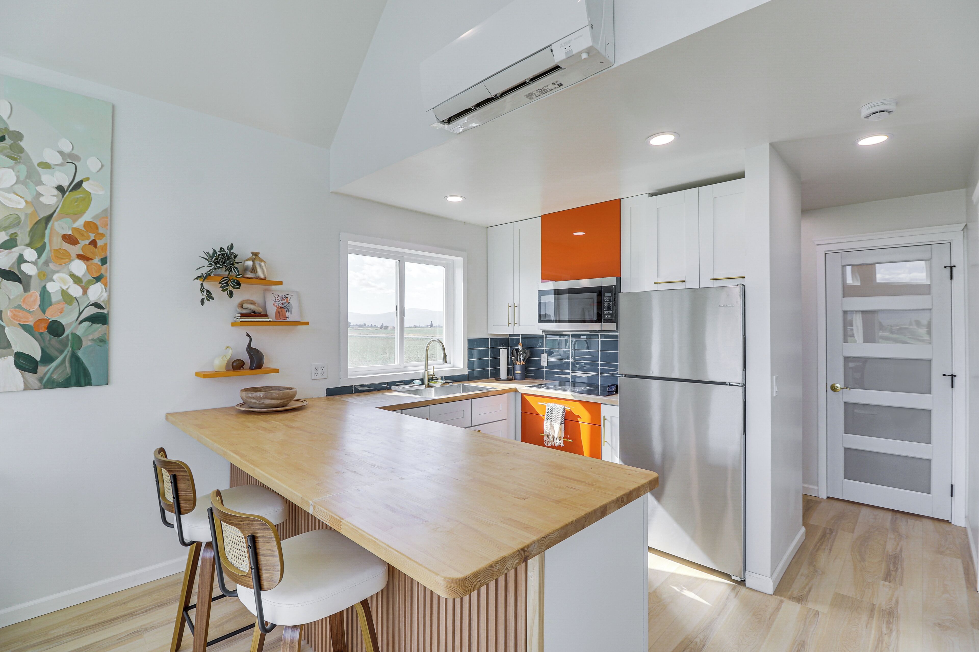 Una cocina moderna con una isla de madera, armarios blancos y vistas a la ciudad.