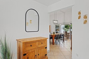 A modern interior with a wooden cabinet, a mirror, and a dining area with chairs and a table. - 3BR Home w/ Private Pool & Patio near Palm Beach (Noord)