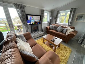 Ein Wohnzimmer mit Kamin, Fernseher, Sofa und Couchtisch.