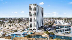 A high-rise hotel with multiple floors, a parking lot, and a pool area. - A110 at the Myrtle Beach Resort (Myrtle Beach)