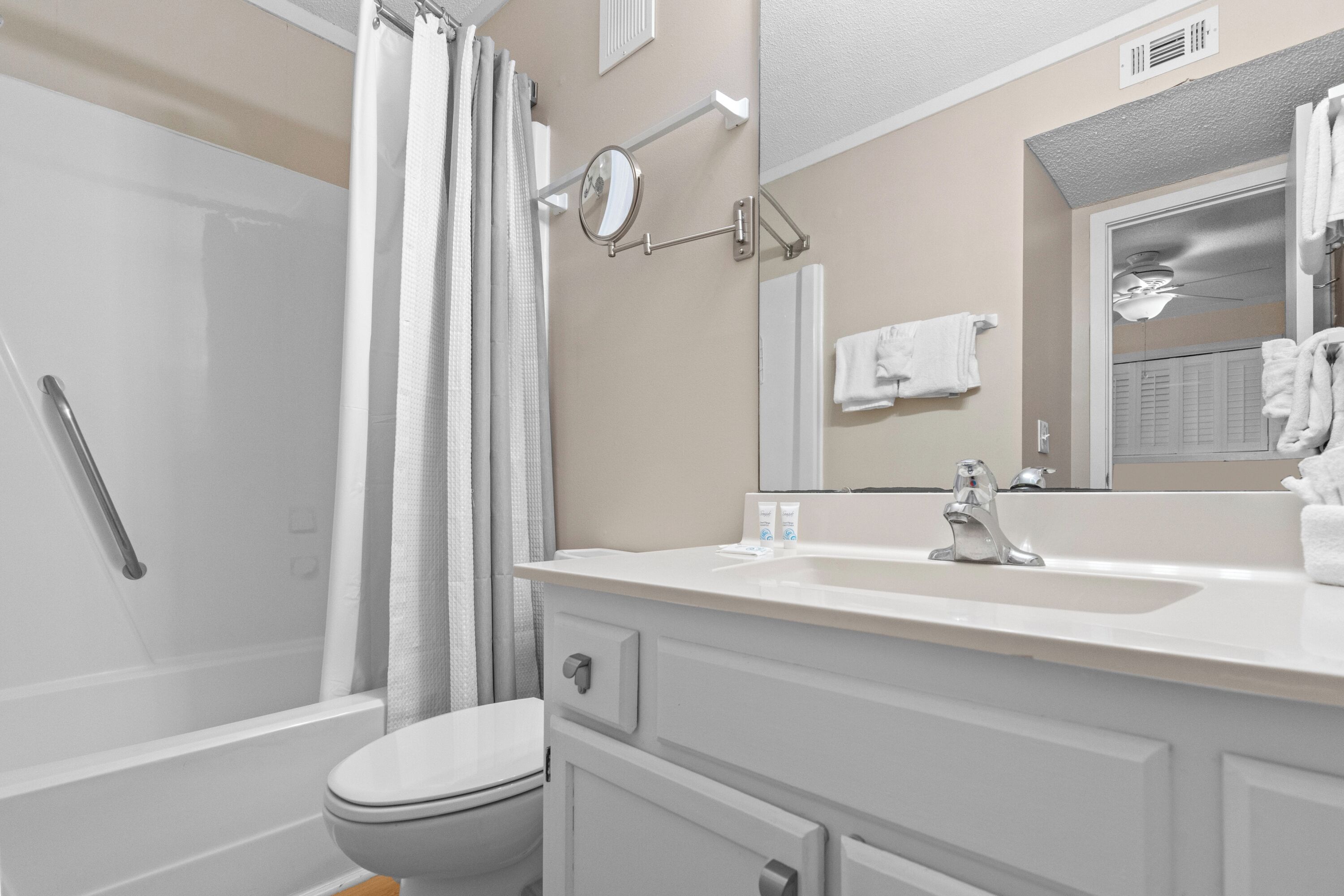 A bathroom with a toilet, sink, and shower.