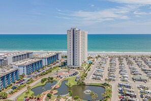 A high-rise hotel with a parking lot and a marina.