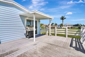 A covered outdoor area with a grill, a white fence, and a view of neighboring houses. - Direct Harbor Access - A Water Lover's Paradise (Punta Gorda)