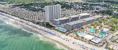 A coastal resort with multiple hotel buildings, a beach, and a water park.