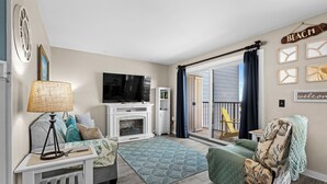 A living room with a TV, fireplace, and a view of the outside. - B214 at Myrtle Beach Resort (Myrtle Beach)