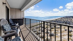 A balcony with chairs and a view of the beach and RVs. - T1210 Myrtle Beach Resort (Myrtle Beach)