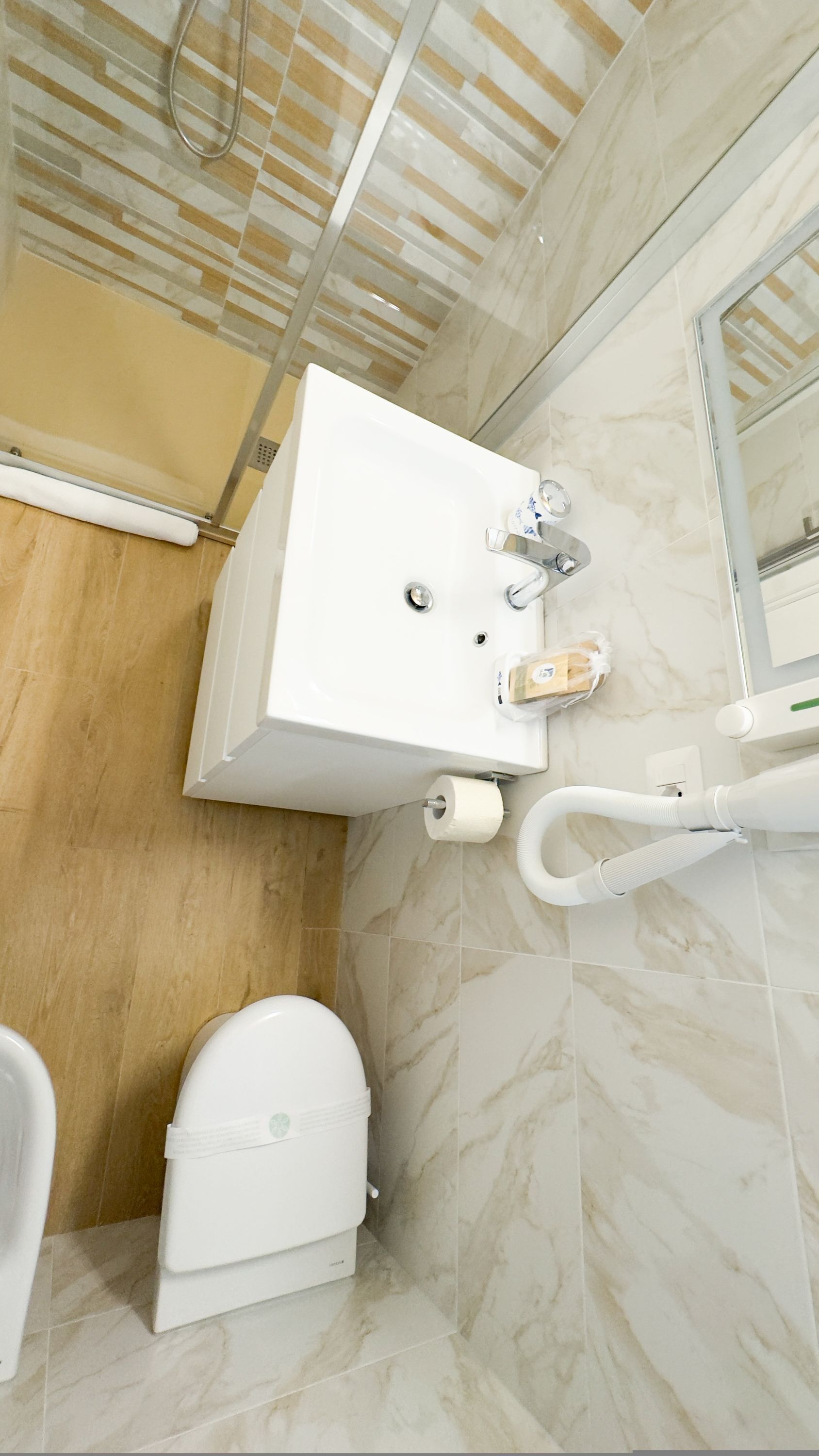Un baño con un lavabo blanco, un inodoro y una zona de ducha.