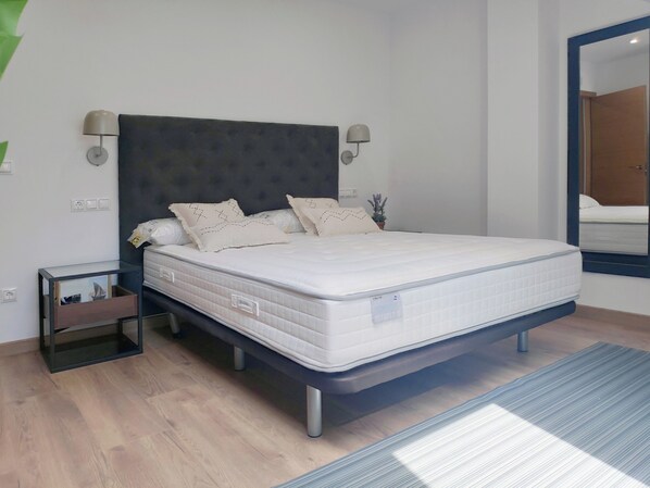 Une chambre à coucher moderne avec un lit, des tables de chevet et un miroir.