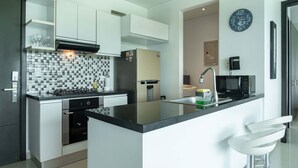 Una cucina moderna con isola centrale, elettrodomestici integrati e forno a microonde.