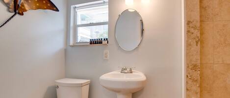 Een badkamer met toilet, wastafel en raam.