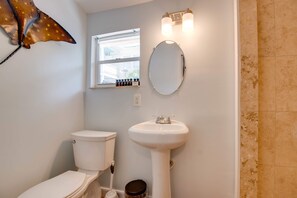 Ein Badezimmer mit Toilette, Waschbecken und einem Fenster.