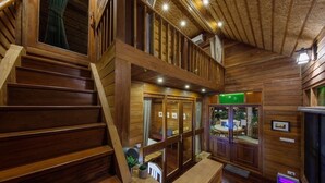 A wooden staircase leading to a balcony with a view of the outdoors.