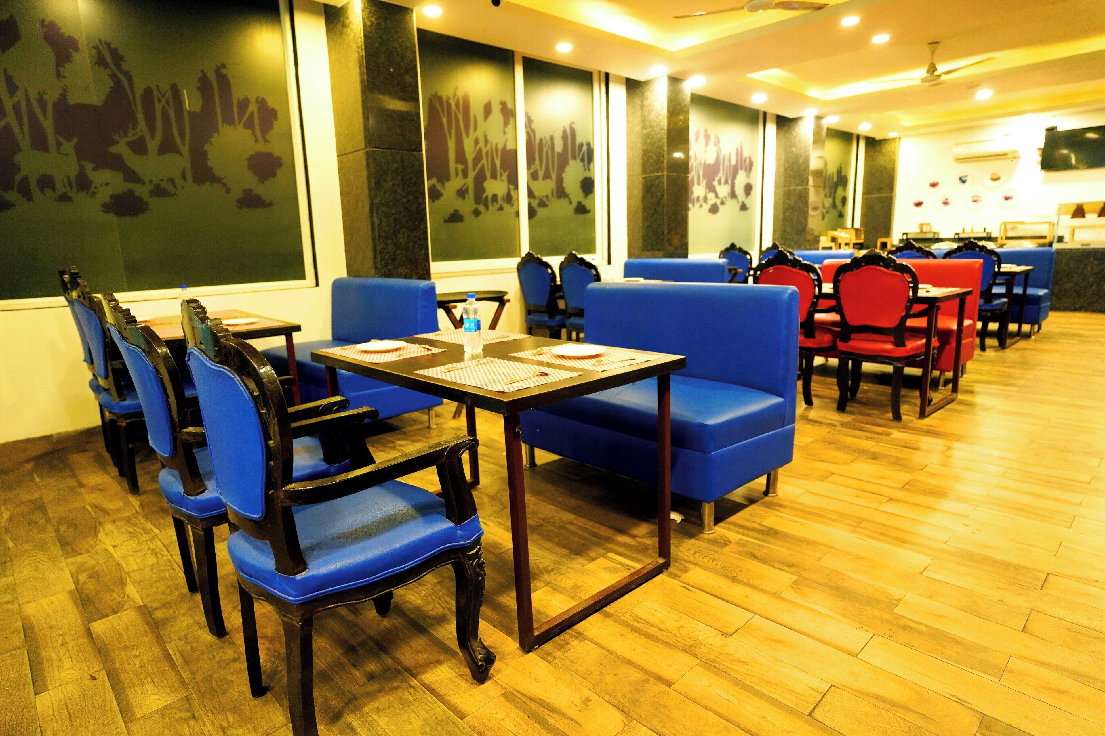 A restaurant with blue cushioned booths and wooden tables, featuring a wooden floor and a large window with a cityscape view.