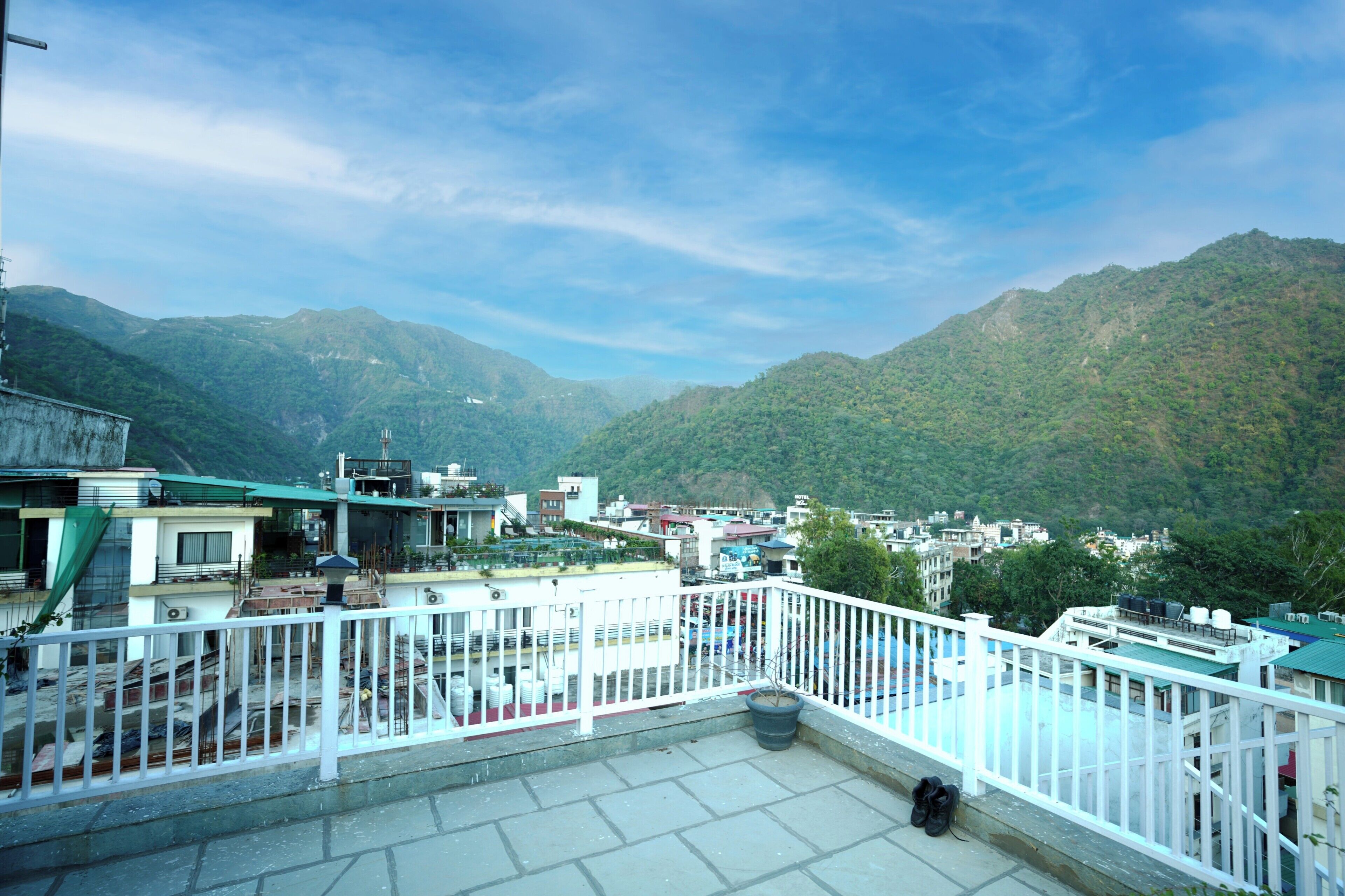 A terrace with a white railing overlooking a mountainous landscape.