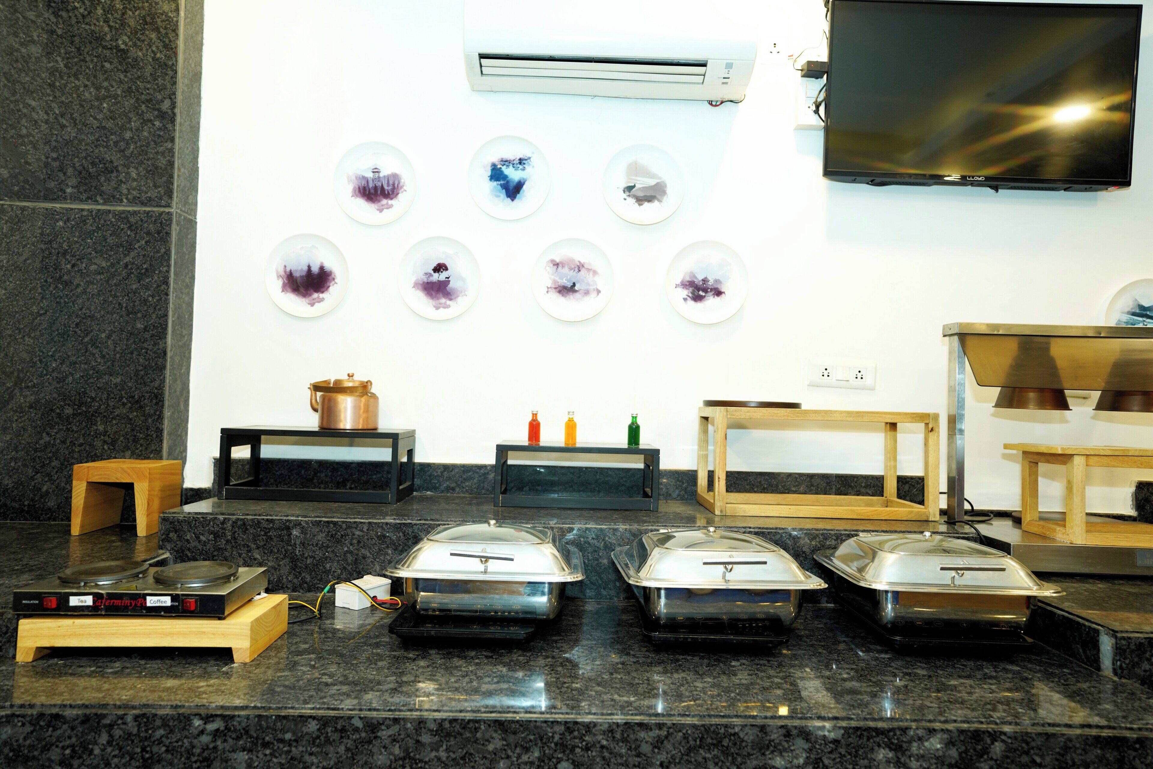 A kitchen area with granite countertops, a coffee machine, a toaster, and a microwave. There are also several small plates with designs on the wall above the counter.