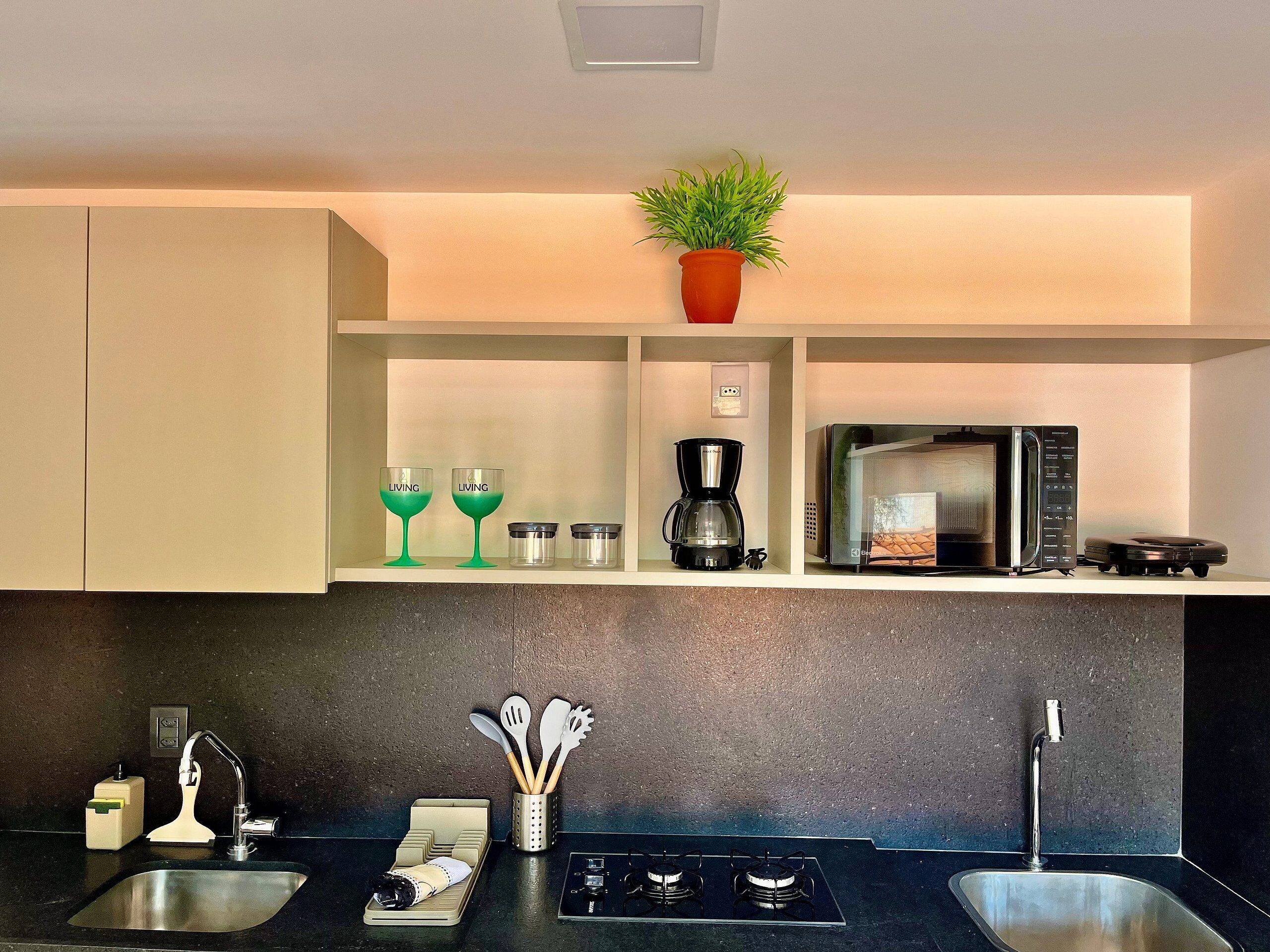 A modern kitchen with a built-in stove, a coffee maker, and a microwave on the countertop.