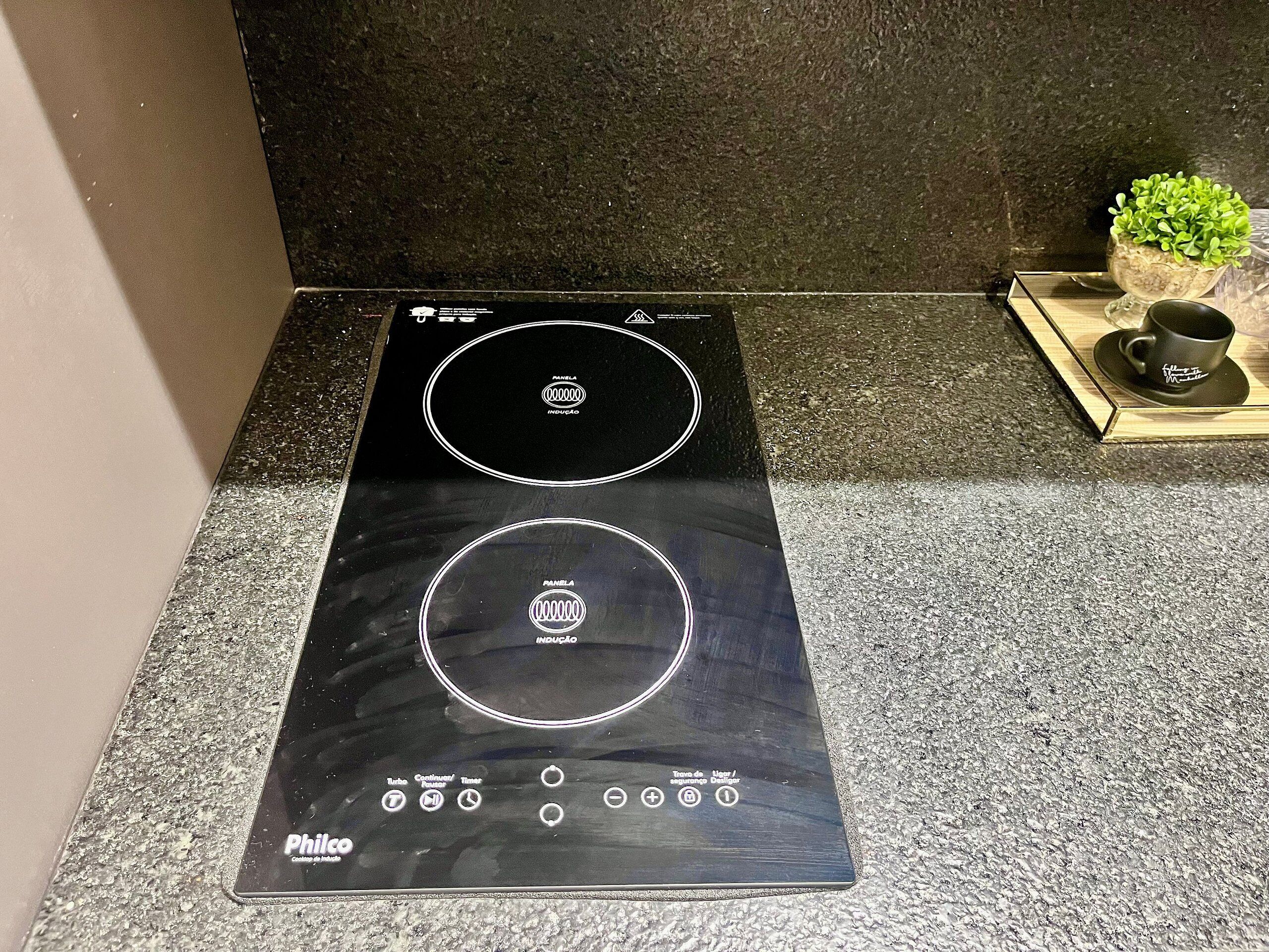 A black induction cooktop with two circular cooking zones and a digital display.