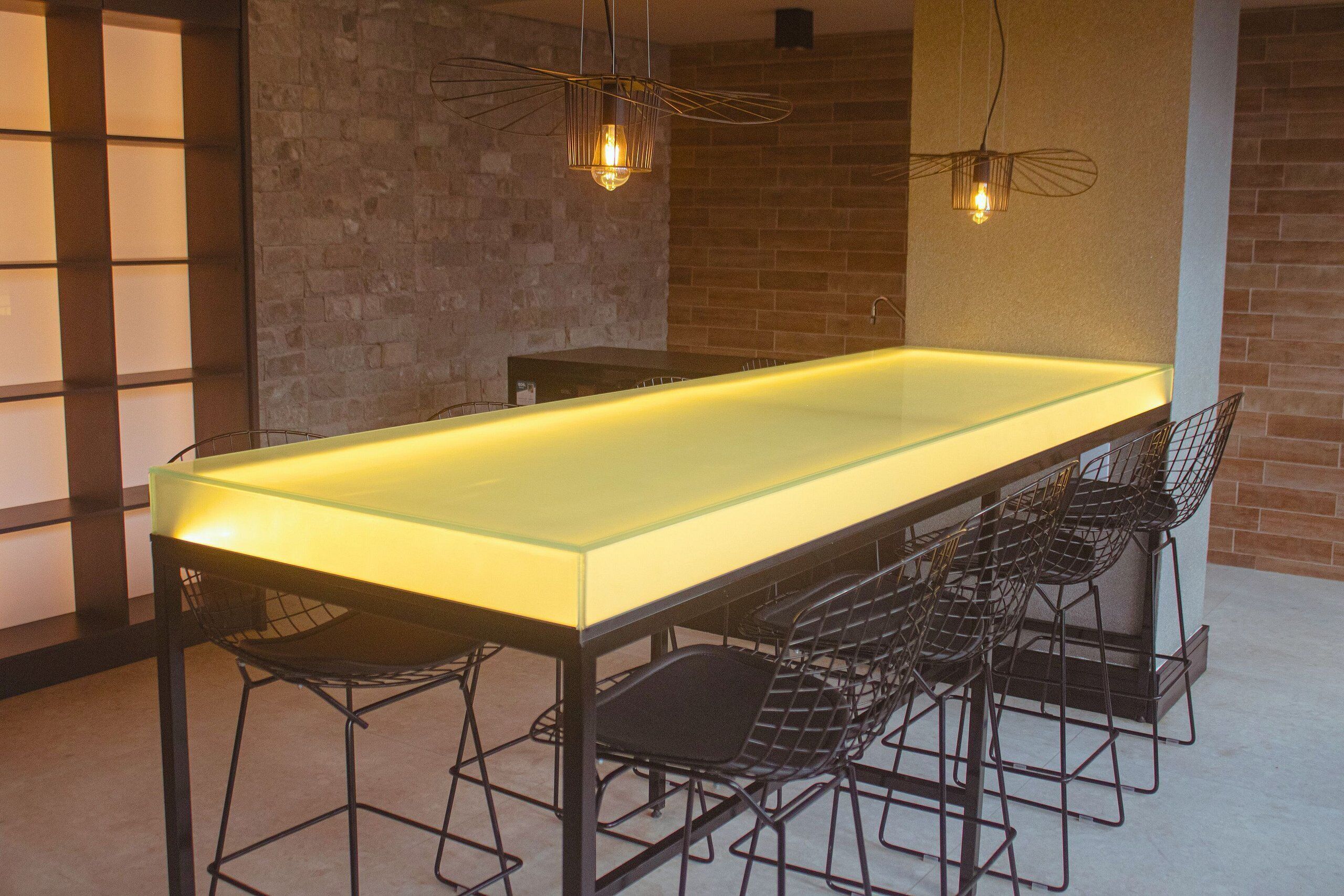 A modern dining area with a long glass table and metal chairs.