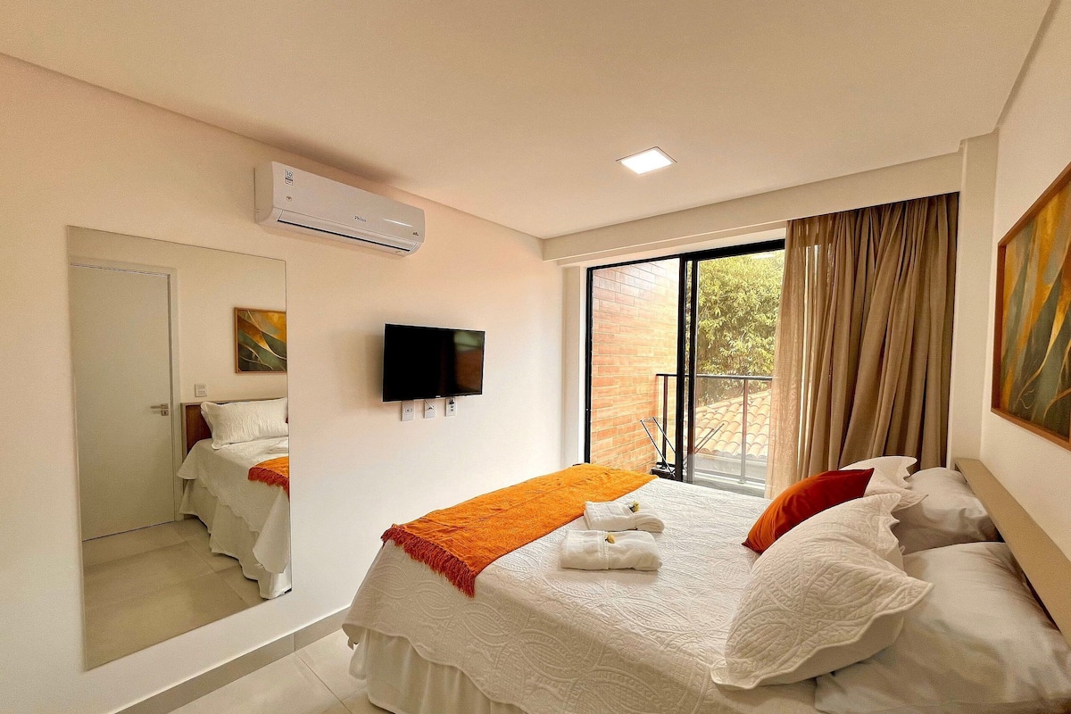 Une chambre d’hôtel équipée d’un lit, d’une télévision, d’un climatiseur, d’une grande fenêtre et d’une porte coulissante.