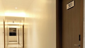 A hotel corridor with a polished floor, a wooden door labeled "301", and a ceiling with recessed lighting. - Hacana Millenium Hotel (Hyderabad)
