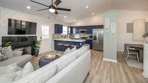 A modern living room with a large TV, sofa, and coffee table. - Walton Arkside Oasis (Walton)
