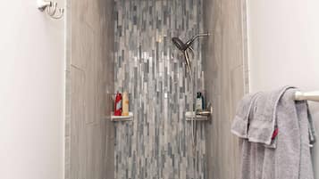 Chuveiro, secador de cabelo, toalhas de banho, shampoo