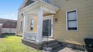 A two-story house with a porch, a front door, and a mailbox. - Northside Suites 3 – A Chic, Relaxed Stay for 2 (Cincinnati)