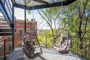 A balcony with two hanging chairs and a metal railing. - OTR 1BR | Balcony + Free Street Parking (Cincinnati)