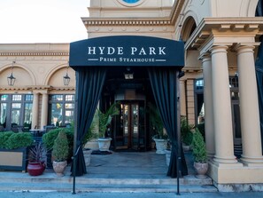 The entrance to Hyde Park Prime Steakhouse with a classic architectural design, featuring columns and a grand entrance.