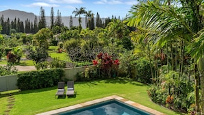 A backyard with a swimming pool, a lawn, and various tropical plants. - Lei Aloha - A Private Retreat, Pool + Fairway views (Princeville)
