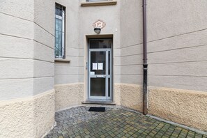 A building entrance with a glass door, a small window, and a metal pipe. - notaMi - MacMaHome (Milan)