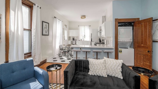 Ein modernes Apartment mit Wohnzimmer, Küche und Essbereich.
