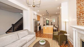 A modern living room with a sofa, coffee table, and fireplace. - Woodburn Villa by Blackhouse (Cincinnati)