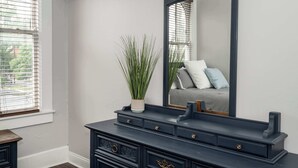 A dark wooden dresser with a mirror and a potted plant. - Heart of Mainstrasse 3 (Covington)