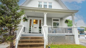 A white two-story house with a front porch, a number "4100" on the door, and a small tree to the left. - The Mariemont Cottage (Cincinnati)