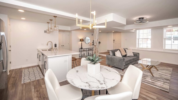 A modern kitchen with white cabinetry, a marble island, and pendant lighting. - *New Listing* Covington Charm Suites (Covington)