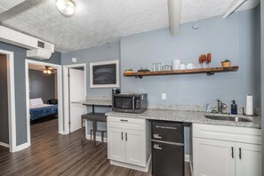 A compact kitchen with white cabinets, a microwave, and a dishwasher.