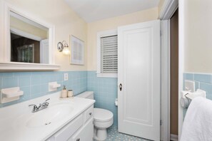 A bathroom with a white sink, a toilet, and a door.