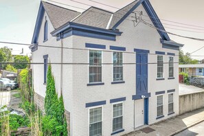 A two-story building with a gabled roof, white brick exterior, and blue trim.