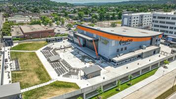 A large, modern building with a curved roof and orange accents, labeled "MegaCorp Pavilion."